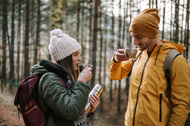 istock Young couple is drinking hot tea during hiking on cold autumn day 1289956581