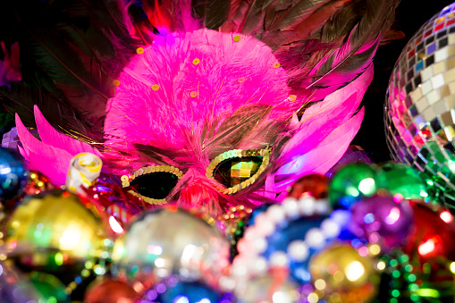 Mardi Gras or Rio Carnival masks and colorful carnival decorations.  Scene includes glittery and colorful feathered masks on black background.