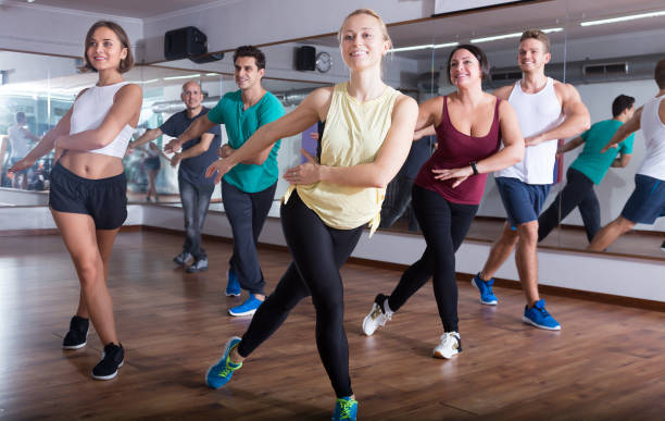 Glad positive people learning zumba steps Glad positive people learning zumba steps in dance hall curtseying stock pictures, royalty-free photos & images