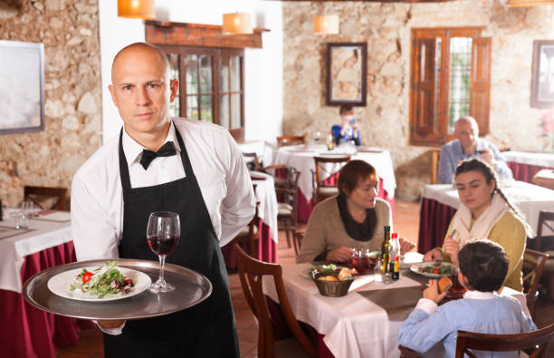 istock Waiter holding tray with dish 1289959844