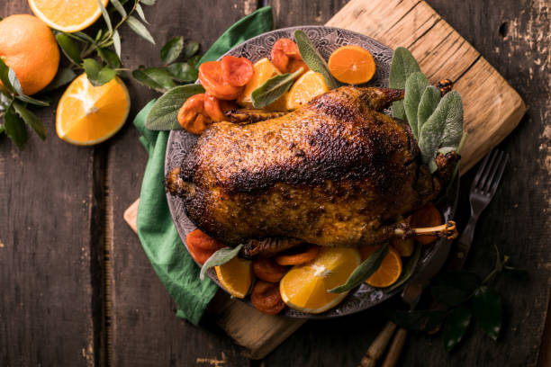 istock Winter Holiday table served for Christmas dinner with roasted duck, decorated with orange and herbs.  New year food 1289962529