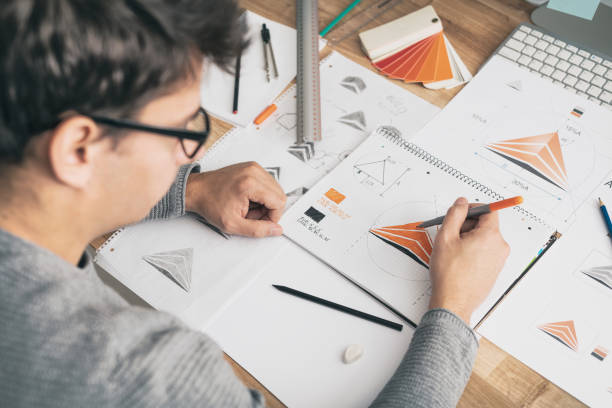 istock Graphic designer drawing sketches logo design. 1289963679