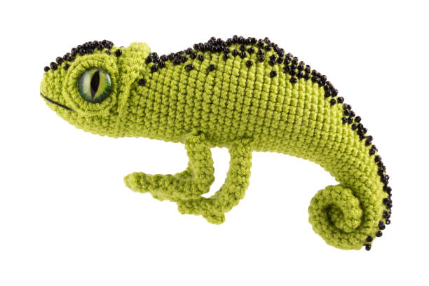 istock Beautiful green knitted chameleon on a white background, soft toy. 1289963700