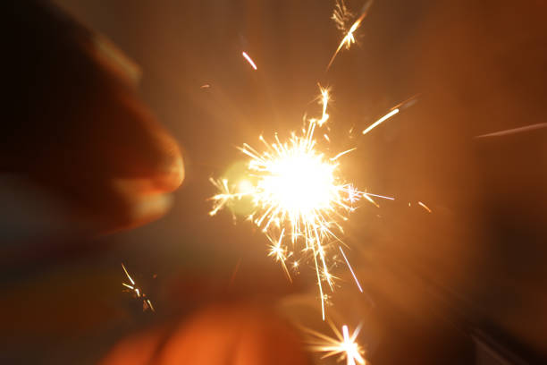 fundo de ano novo de fogos de artifício brilhantes na mão. - sparkler sparks new years eve human hand - fotografias e filmes do acervo