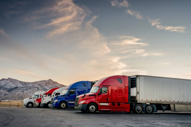 caminhões vermelhos brancos e azuis estacionados alinhados em uma parada de caminhões - land vehicle truck semi truck trucking - fotografias e filmes do acervo