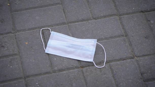 istock On the sidewalk is a used protective mask. Such garbage carries a biological danger to others 1289965540