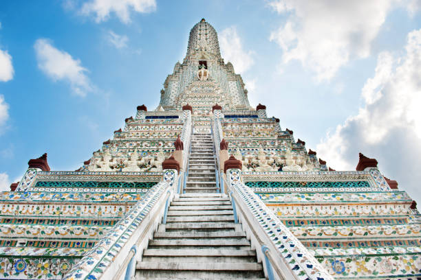 Front view of main Wat Arun prang with stairs in Bangkok, Thailand Front view of main Wat Arun prang with stairs and sculptures on blue sky background. Architectural landmark in Bangkok, Thailand wat arun stock pictures, royalty-free photos & images
