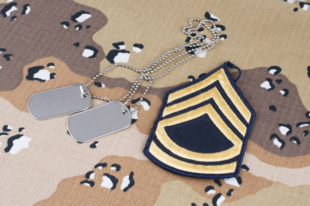 istock US ARMY Sergeant First Class rank patch and dog tags on Desert Battle Dress Uniform 1289967756