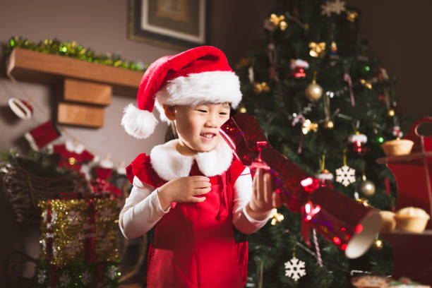 istock young girl playing Christmas cracker in front of Christmas tree 1289968539