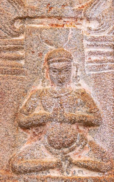 Closeup of mural sculpture of yogi at Virupaksha temple, Hampi, Karnataka, India. Hampi, Karnataka, India - November 4, 2013: Virupaksha Temple complex. Closeup of red stone with beige spot stone sculpture of yogi in sitting position. virupaksha stock pictures, royalty-free photos & images