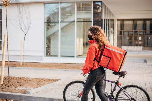 istock Woman with face mask doing food delivery with bicycle 1289970322