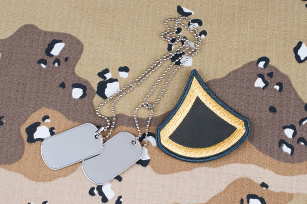 istock US ARMY Private First Class rank patch and dog tags on Desert Battle Dress Uniform 1289971014
