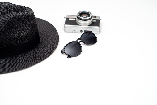 Bathing suit, sunglasses, hat, and camera laid out ready to pack for a spring break or beach vacation.