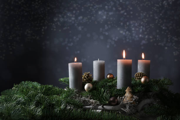 istock Third advent with three burning candles on fir branches with Christmas decoration against a dark grey background, copy space 1289976194