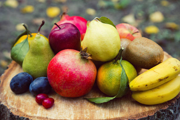 istock Mixed fruits on wooden plate 1289976403