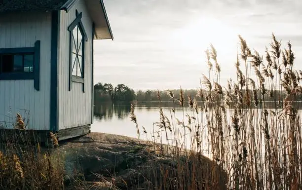 Photo of traditional Swedish hut on some rocks in the winter sun in Sweden