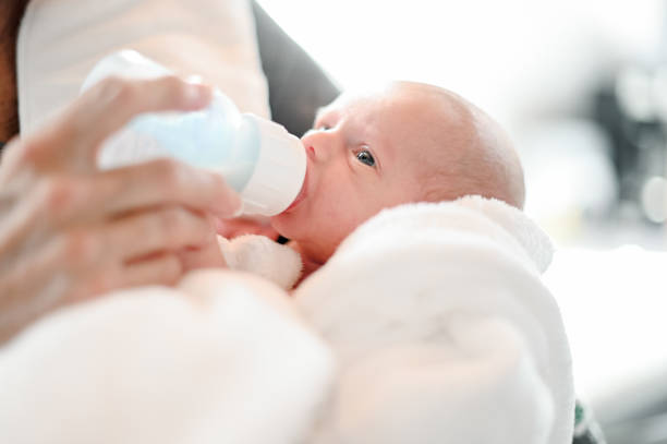 Tiny little newborn baby and a baby bottle