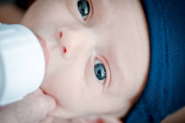 Tiny little newborn baby and a baby bottle