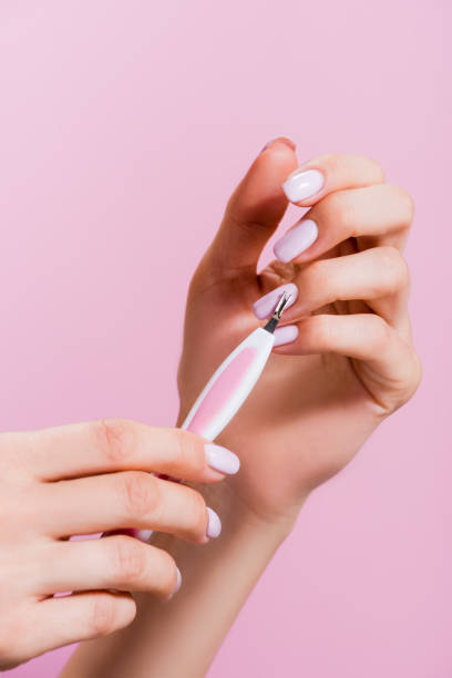 istock cropped view of woman using cuticle clipper isolated on pink 1289981408