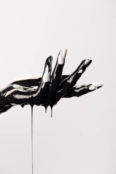 istock cropped view of hand with dripping black paint isolated on grey 1289981937