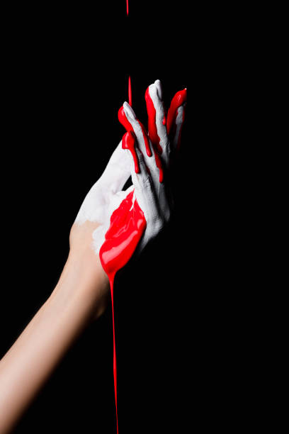 istock partial view of white painted hand with red dripping paint isolated on black 1289981944