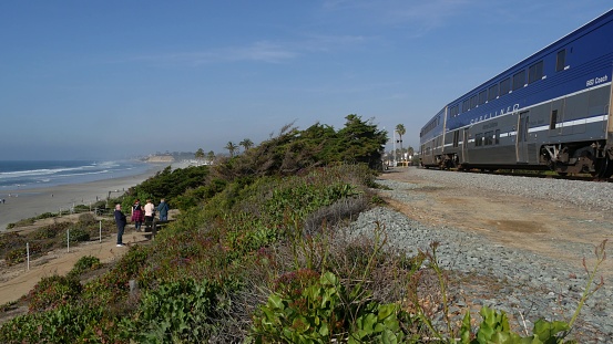 Del Mar, California USA - 23 Jan 2020: Pacific surfliner train, travel ocean beach. Passenger railroad, public transit. Express rapid intercity double decker blue commuter. Amtrak railway transport.