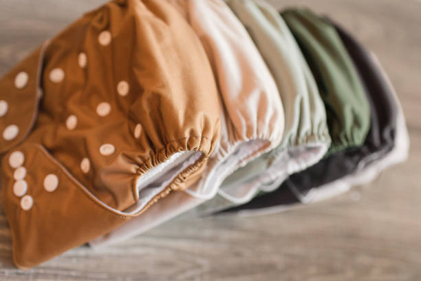 A Stack of Modern Neutral-Colored Reusable Cloth Diapers with a Neutral Background in Bright Natural Light