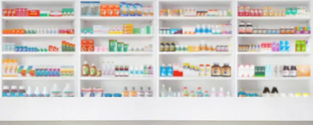 Empty wood counter top with pharmacy drugstore shelves blur pharmaceutical medicine product background