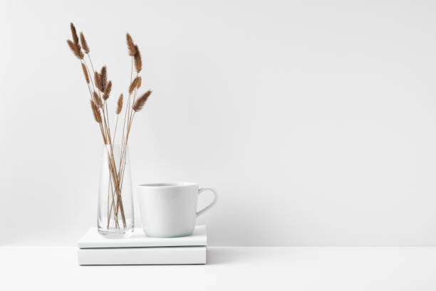 istock A mug on a stack of books and a transparent vase with dried flowers. Eco-friendly materials in interior decor, minimalism. Copy space, mock up. 1289990257