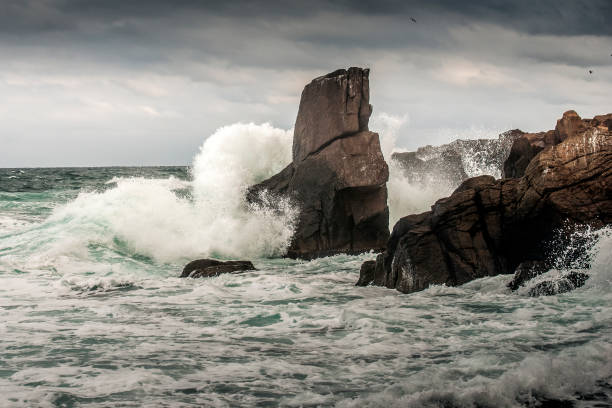 istock Powerful waves crashes in rocky coastline 1289990312