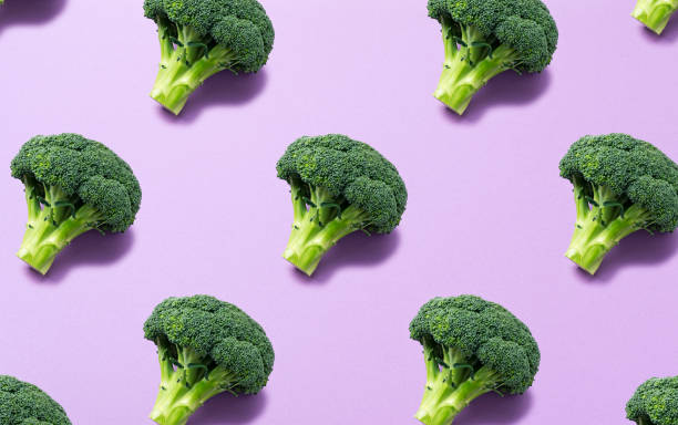 Broccoli lined up regularly on a purple background. Background material