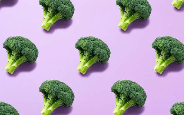 Photo of Broccoli lined up regularly on a purple background. Background material