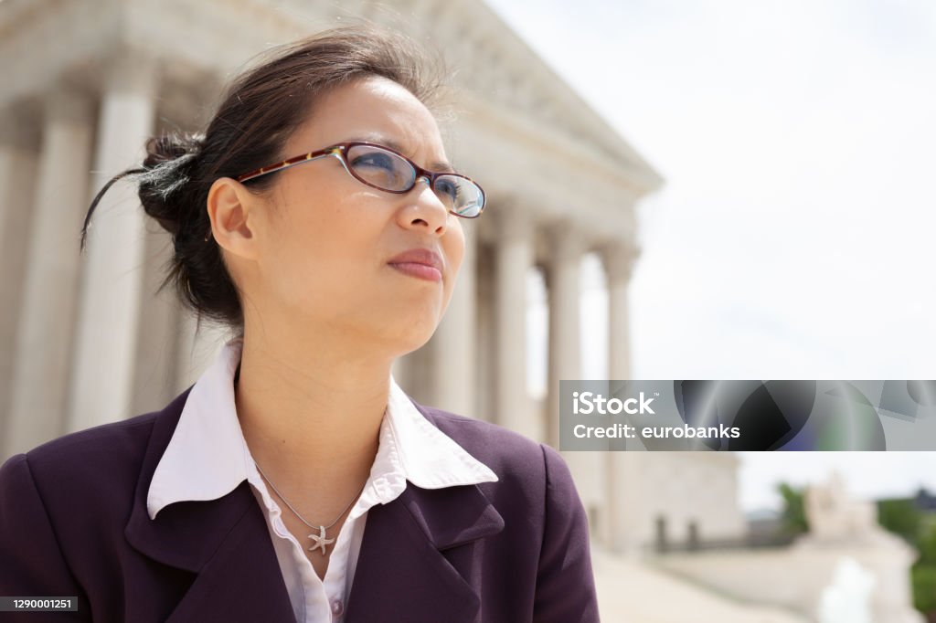 Asian Businesswoman at the Supreme Court in Washington, DC Beautiful mid adult Asian American woman in front of the U.S. Supreme Court building in Washington, DC Government Stock Photo