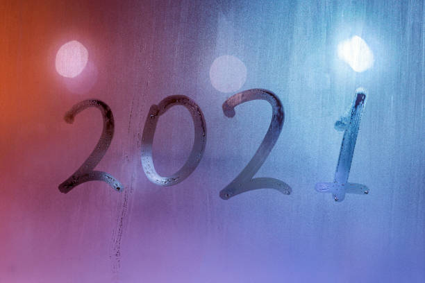 istock digit 2021 handwritten on wet night window glass surface 1290002030