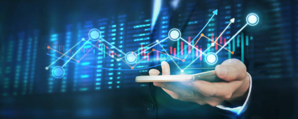 istock Hand holding smartphone device and touching screen. businessman trader looking on with graphs analysis candle 1290003741