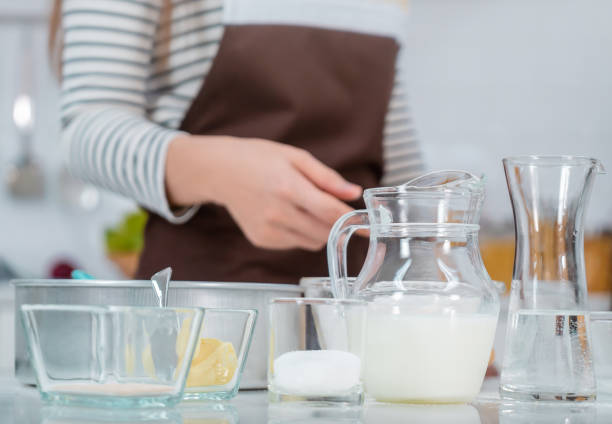 istock Woman is preparing Bakery ingredients on kitchen counter table with milk egg water and flour. 1290003959