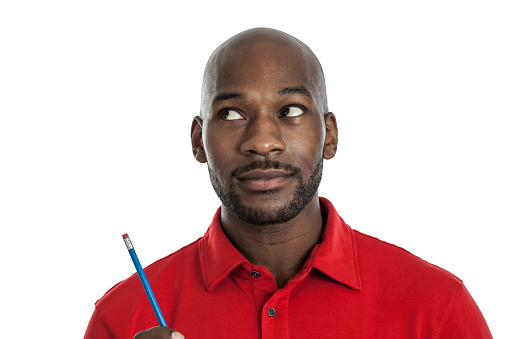 Handsome late 20s black man with a pencil thinking isolated on a white background