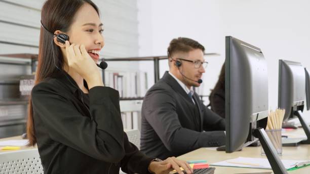 istock Business people wearing headset working in office 1290009227