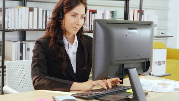 istock Business people wearing headset working in office 1290010110
