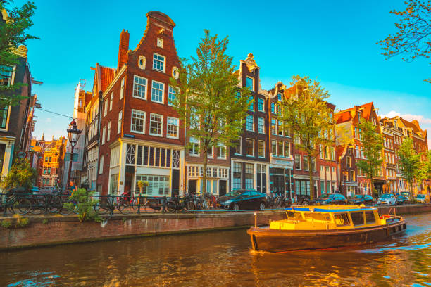 Typical street in Amsterdam, Netherlands Beautiful Amsterdam sunset. Typical old dutch houses on the bridge and canals in spring, Netherlands jordaan amsterdam stock pictures, royalty-free photos & images