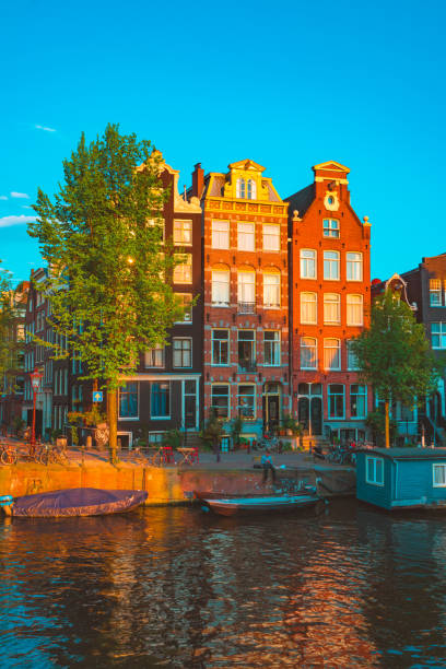 Typical street in Amsterdam, Netherlands Beautiful Amsterdam sunset. Typical old dutch houses on the bridge and canals in spring, Netherlands jordaan amsterdam stock pictures, royalty-free photos & images