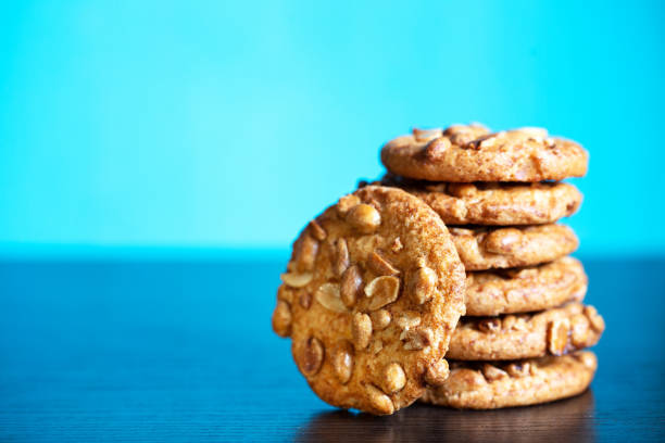 istock Stack of oatmeal cookies with peanuts on blue background 1290017601