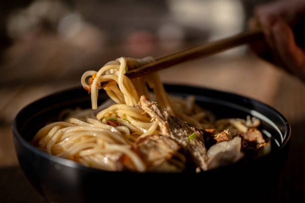 hand holding chopsticks, ready to eat noodles