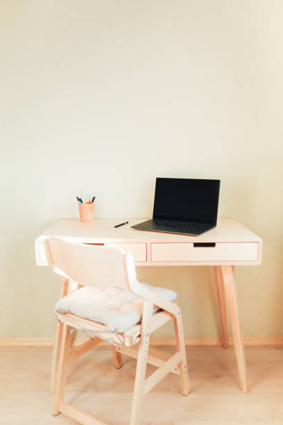 istock Black laptop on table in home interior. Stylish workplace 1290019660