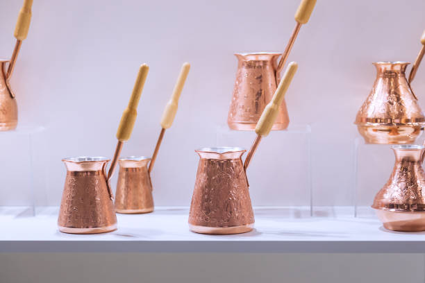 Selling a Lot of Cezve Copper for Brewing Coffee in a Shop window on a Shelf in the Crockery Department Selling a Lot of Cezve Copper for Brewing Coffee in a Shop window on a Shelf in the Crockery Department turkish coffee pot cezve stock pictures, royalty-free photos & images