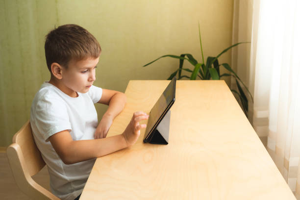 istock Cute child doing homework with laptop at home 1290020460