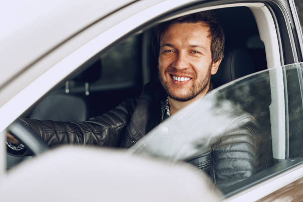 istock Confident young man sitting in a car 1290025587