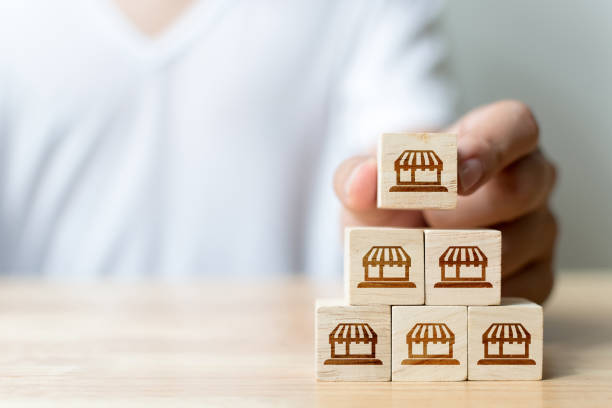 istock Franchise business marketing system concept. Structure service store network strategy. Hand putting wooden block on top with icon store 1290026098