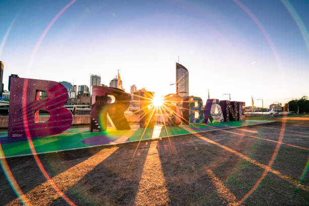 Brisbane Southbank October 6, 2016. The Brisbane sign is a collection of 2 metre 'letter' blocks spelling out the name BRISBANE, designed by The Queensland Mens Shed, a community project. The sun is rising over the city and between the large letters, there is lens flare which makes a creative border for the sign.