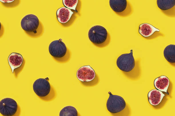 istock Fresh figs whole and sliced figs on yellow background. Food pattern. 1290029511